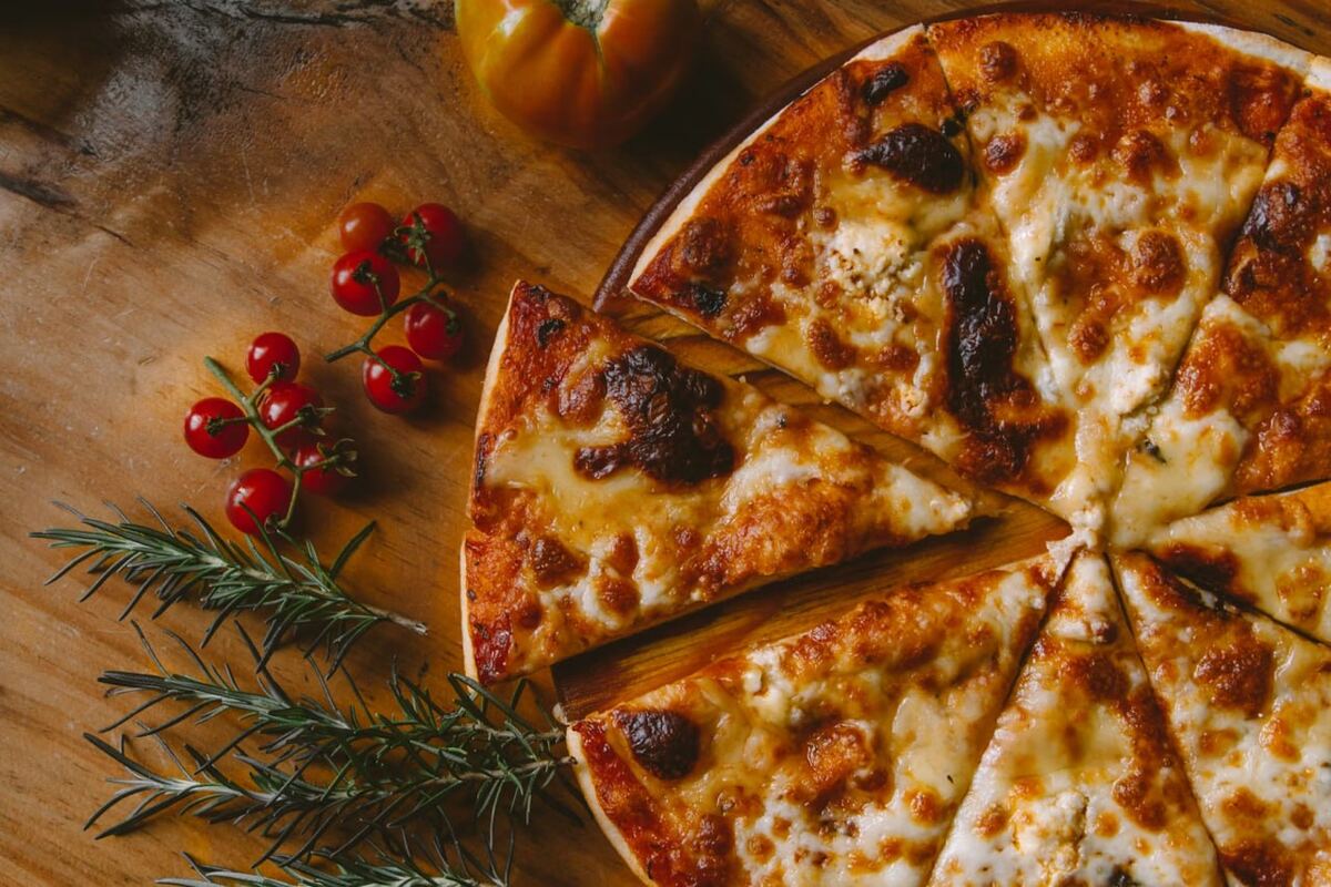 Several slices of cheese and tomato pizza arranged together on a wooden table