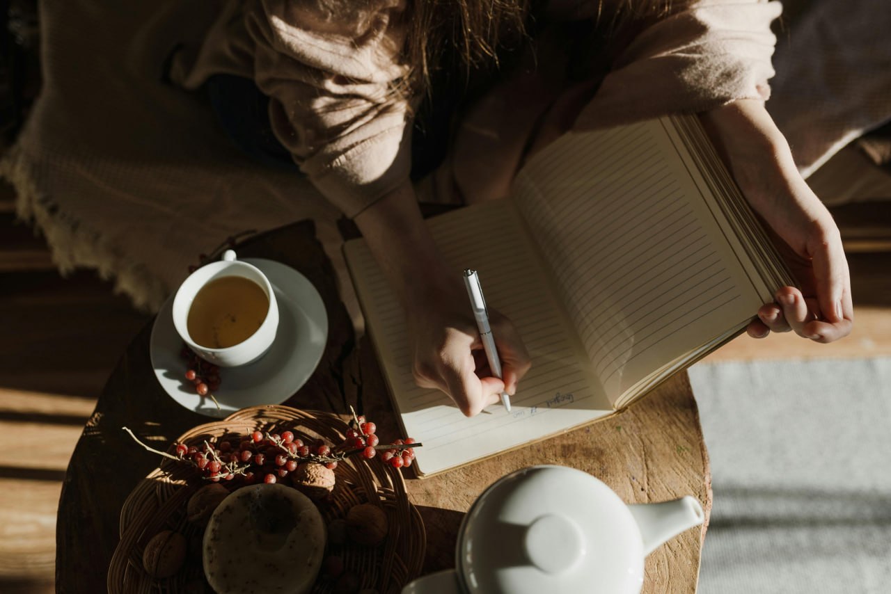 Journaling with tea in warm light — tracking mood and food together