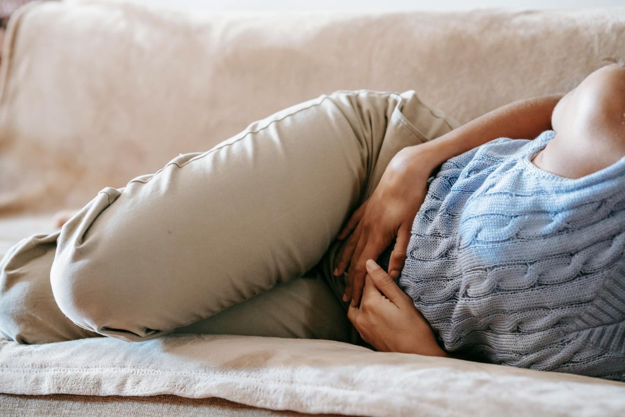 Lying on the couch with stomach discomfort — when your gut and brain are both struggling