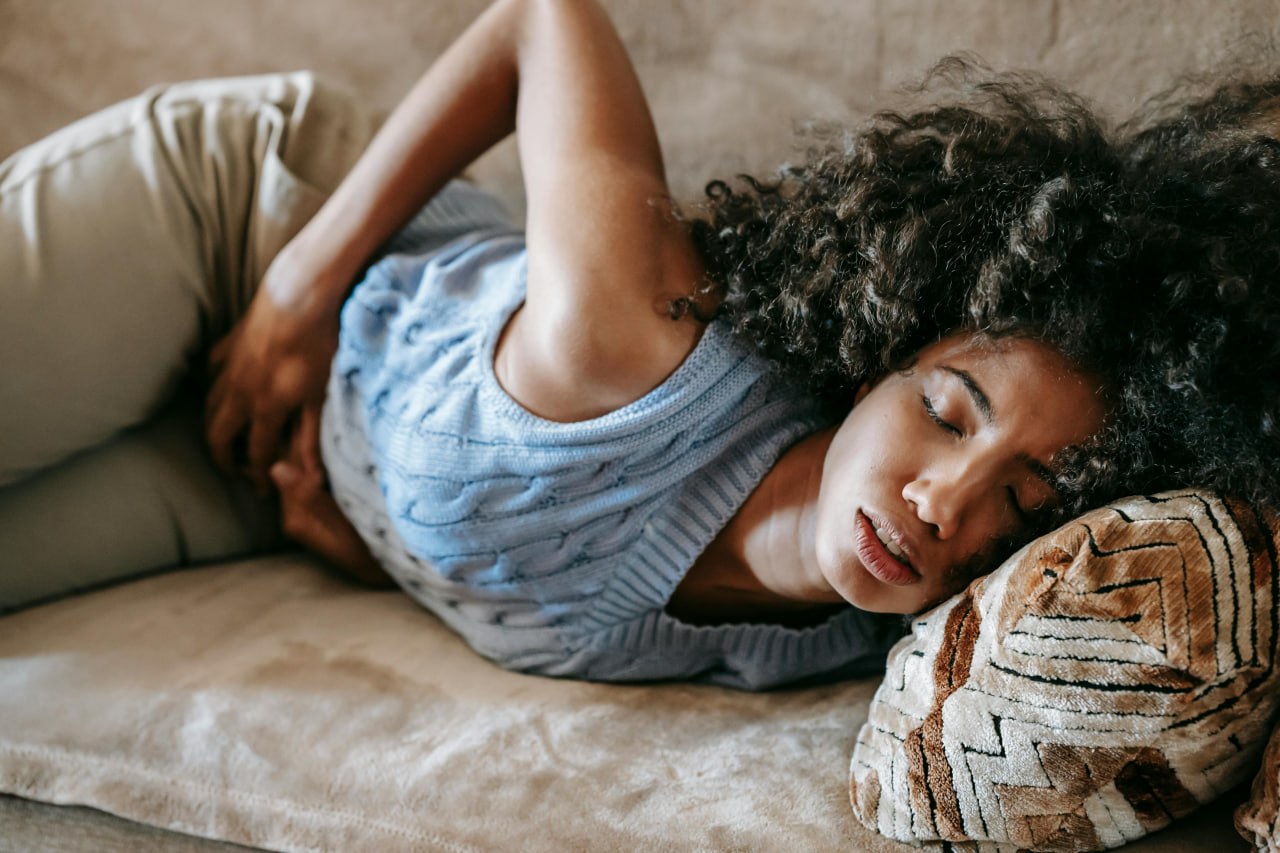 Curled up on the couch with stomach pain — stress and IBS feeding off each other