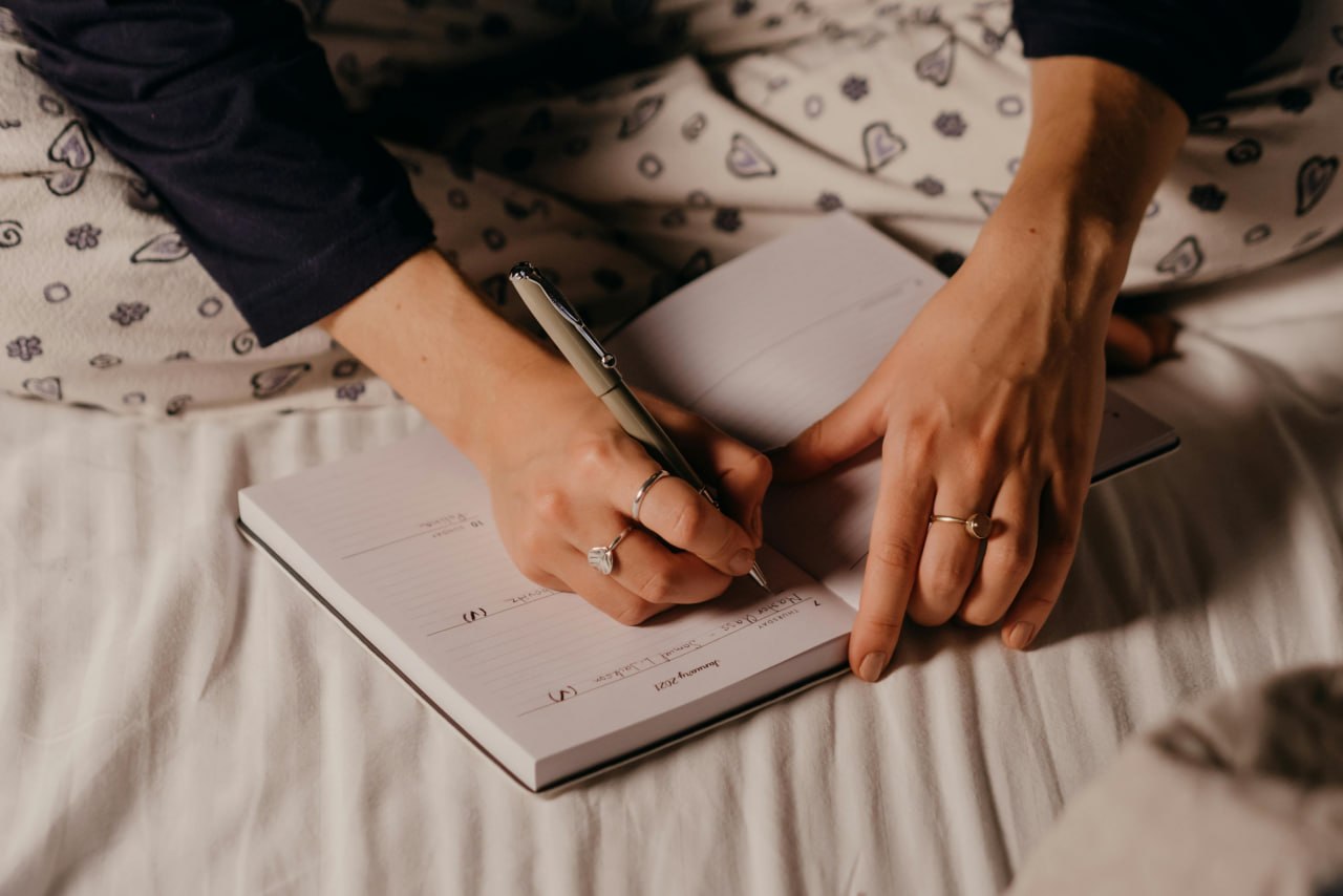 Writing in a food journal before bed — noting what you ate and how you felt